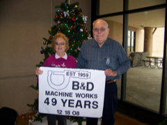 Mr. & Mrs. Dickey holding sign that reads "B&D Machine Works, 49 Years, 12/10/2008"